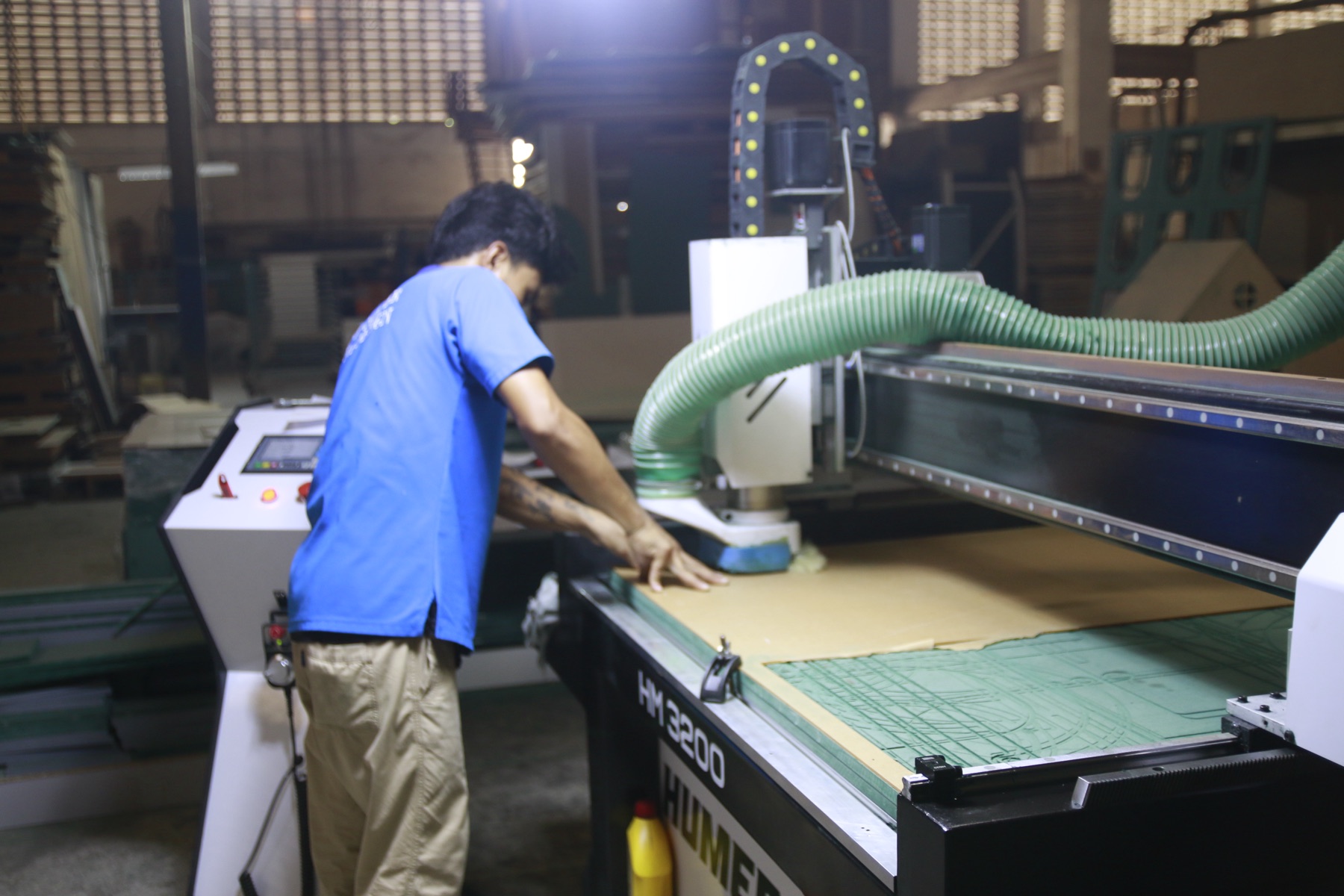 A craftsman operating a CNC machine in the HAÜS workshop